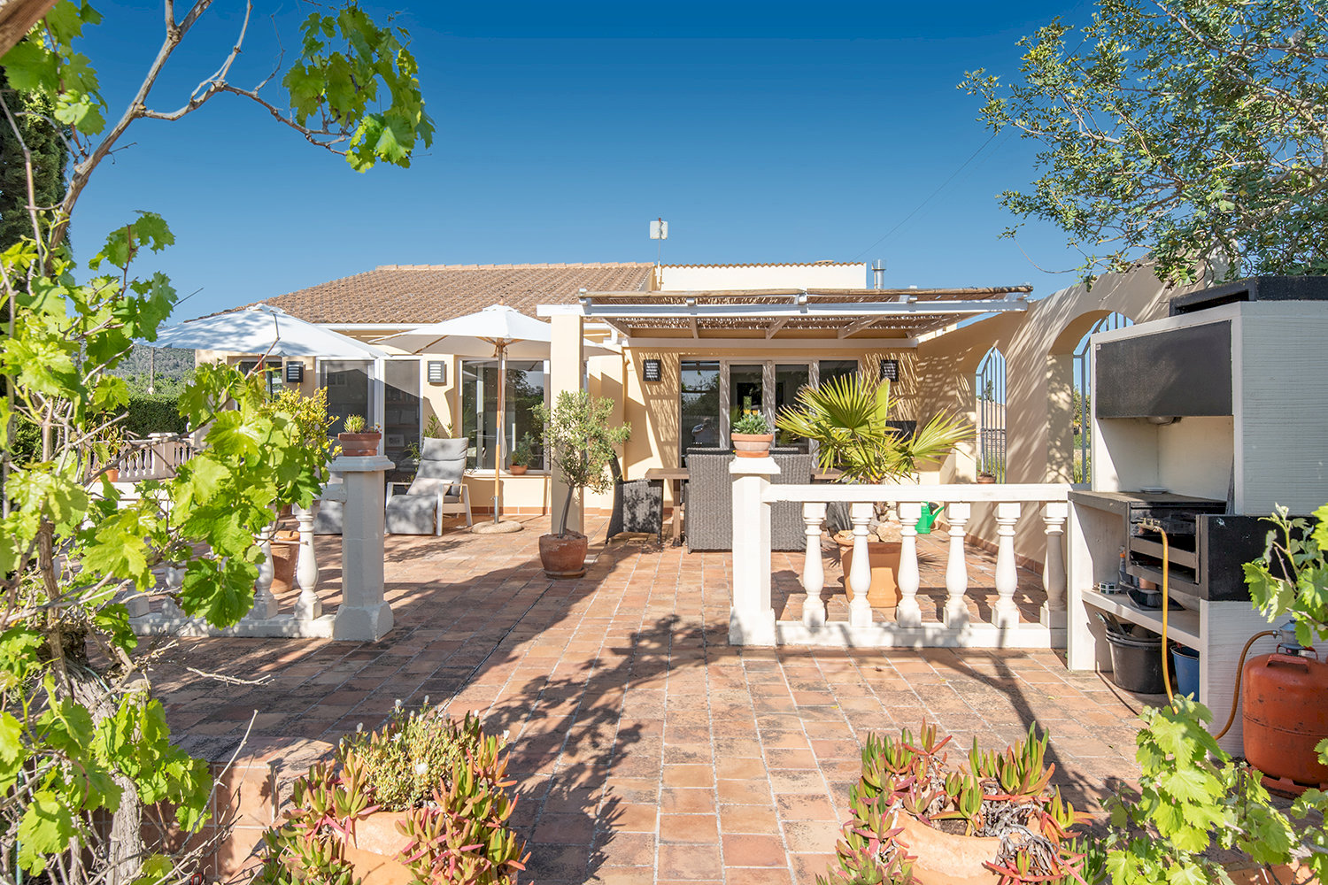 Cocina exterior mediterránea y terraza para momentos sociales