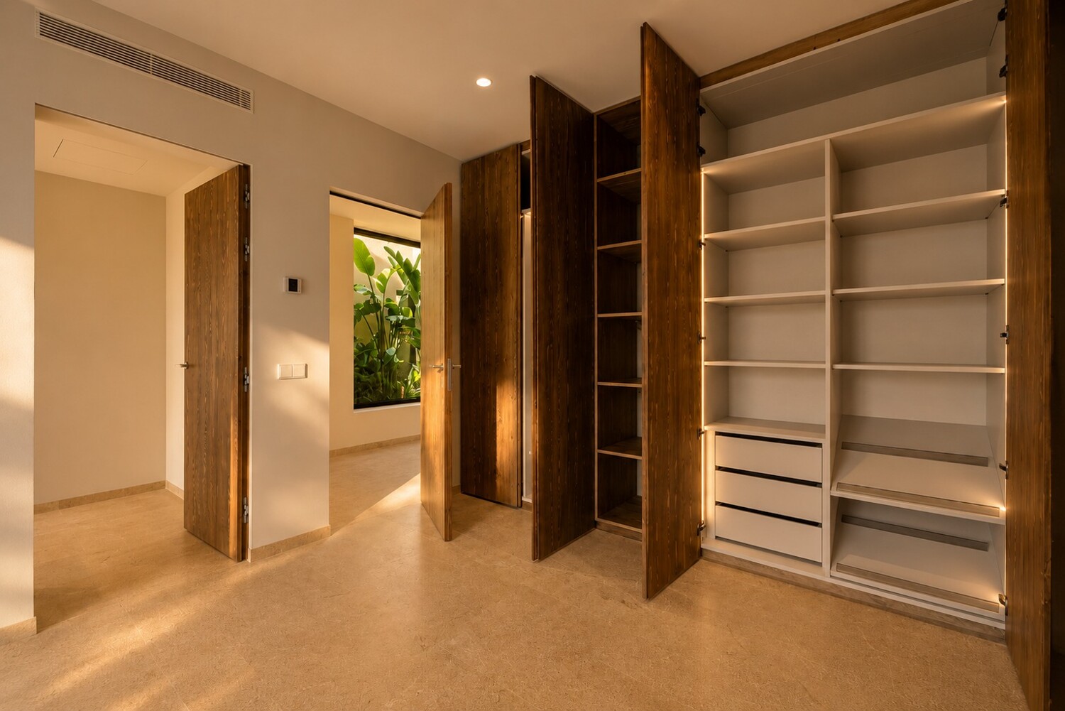 Zona de vestidor con armarios empotrados, carpintería de madera y distribución funcional de almacenamiento