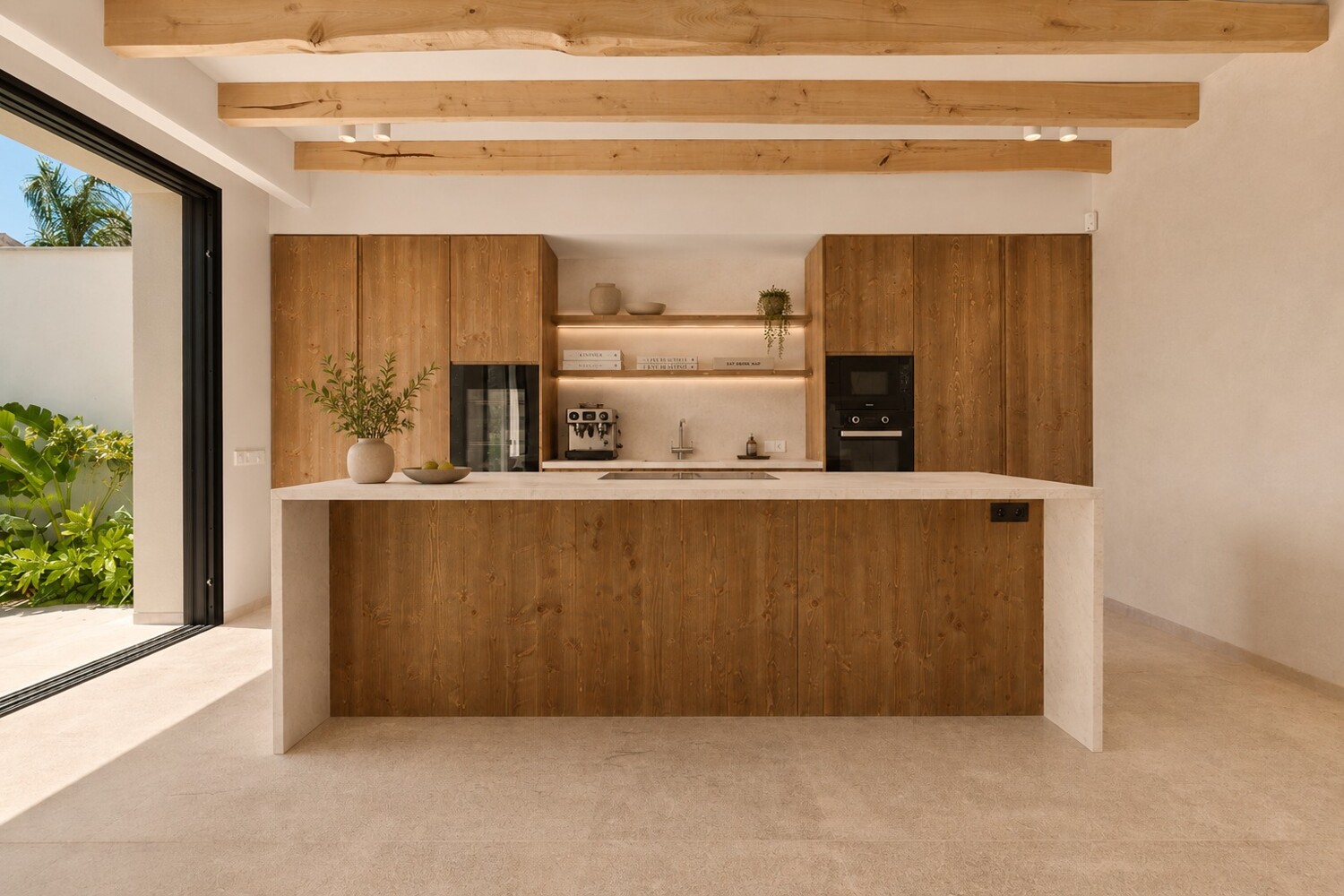 Cocina abierta con isla central, electrodomésticos integrados y carpintería de madera de alta gama