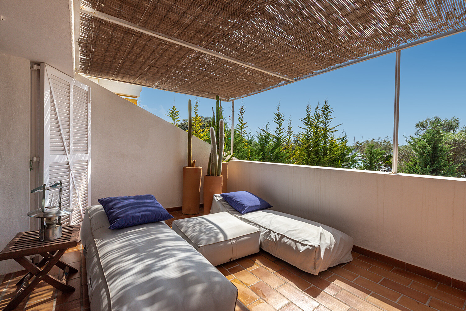 Terraza cubierta con cómodas tumbonas y vistas al entorno mediterráneo
