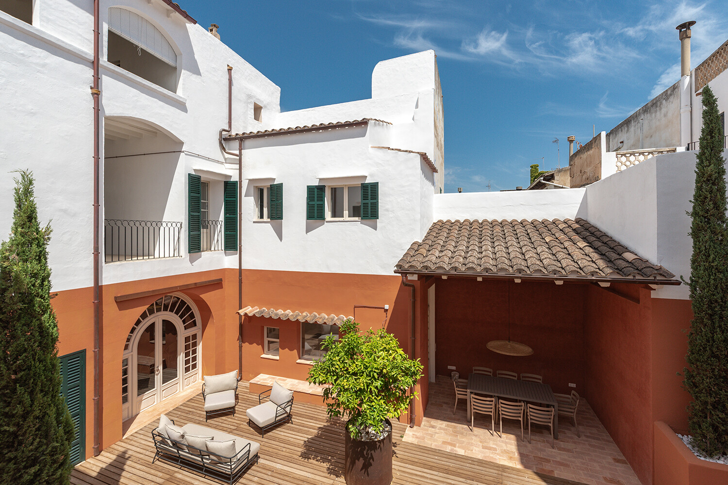 Patio señorial con terraza cubierta, portal histórico de arco de medio punto y zona lounge