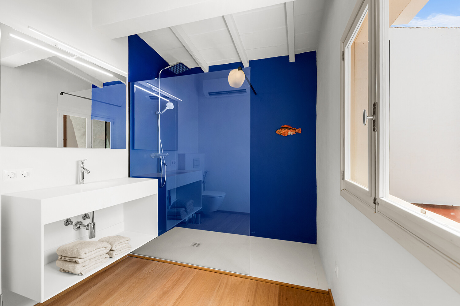 Baño moderno con amplia ducha walk-in y una estética limpia y minimalista