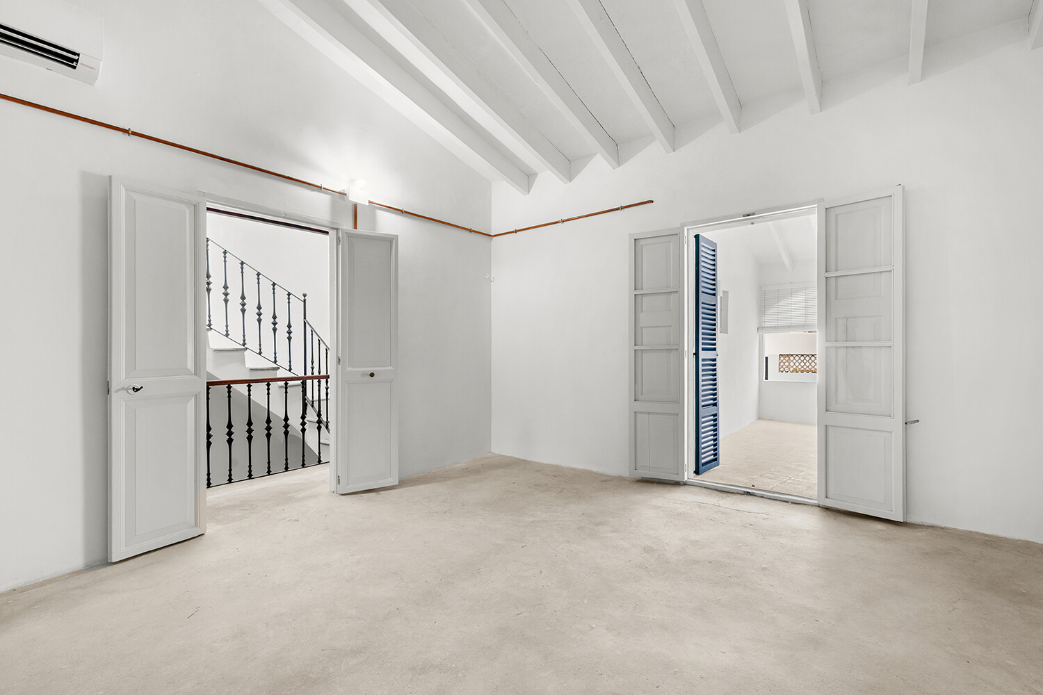 Amplia estancia en planta superior pendiente de personalización, con vigas vistas y acceso al balcón